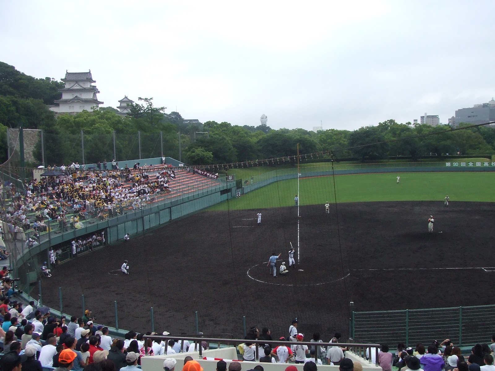 三塁側スタンドの後方に明石城の建造物が見える